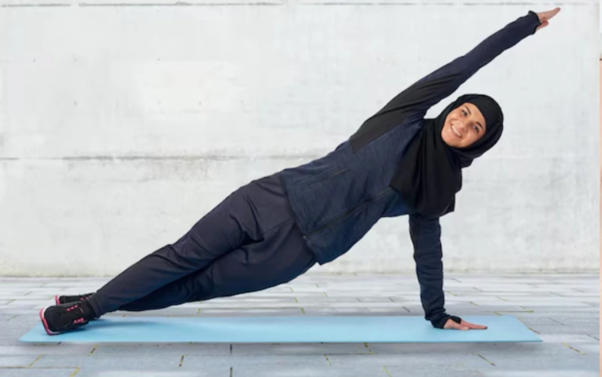 Perempuan berhijab tengah melakukan olahraga ringan.