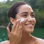 Seorang perempuan menggunakan sunscreen saat berlibur.(freepik)