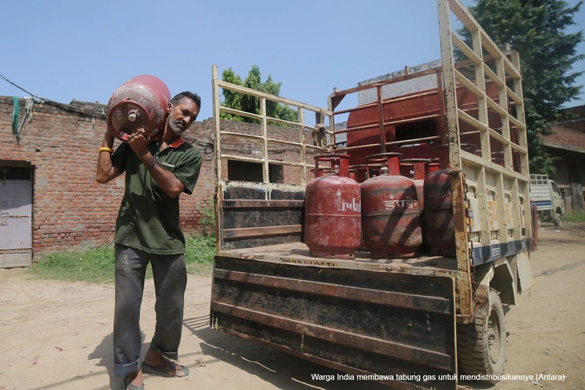 Warga India membawa tabung gas untuk mendistribusikannya.(Antara)