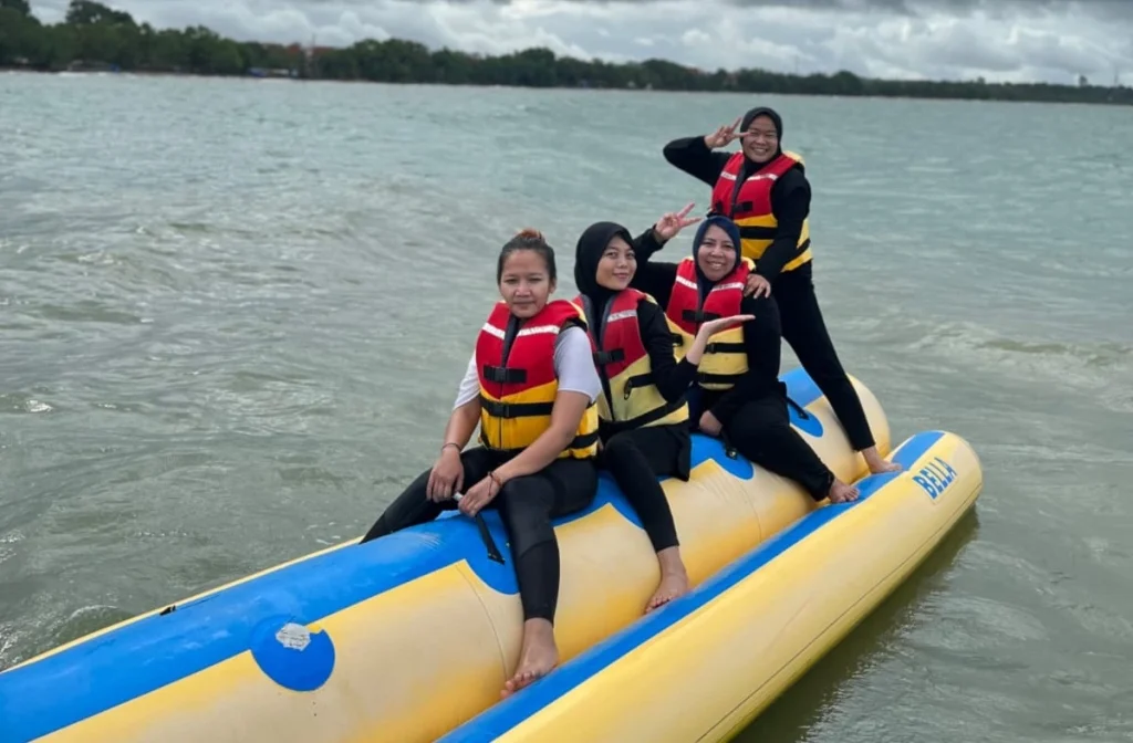 Wisatawan berhijab tengah menjajal banana boat di kawasan wisata Pantai Carita, Pandeglang, Banten