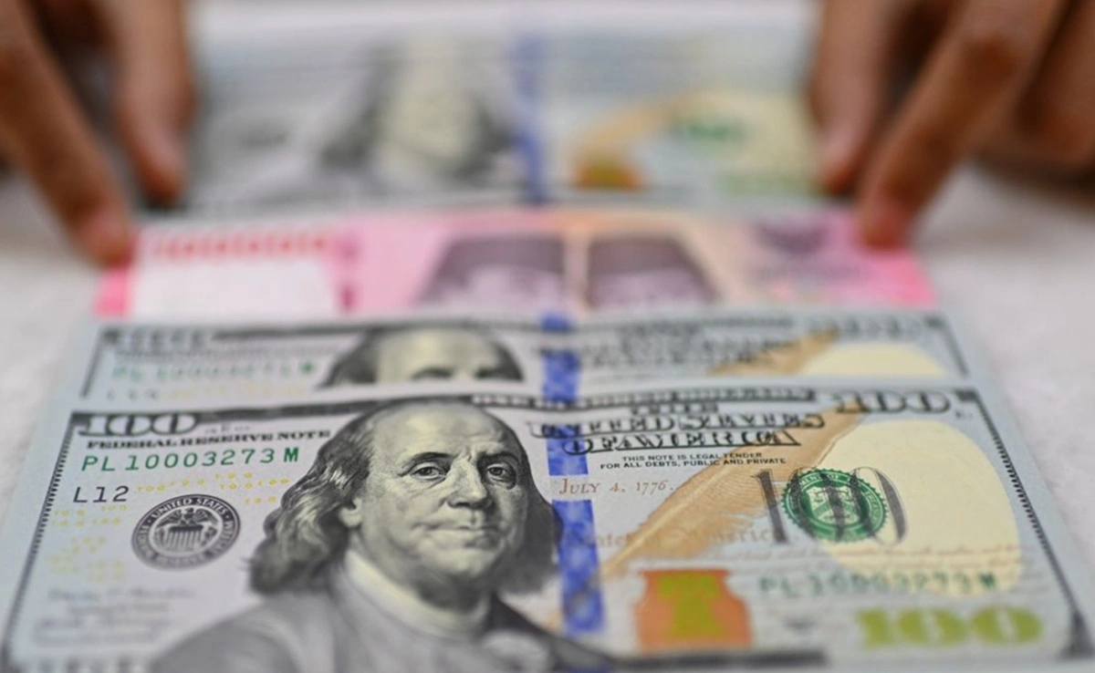 Seorang teller bank menjajarkan uang USD dan Rupiah.(Antara)