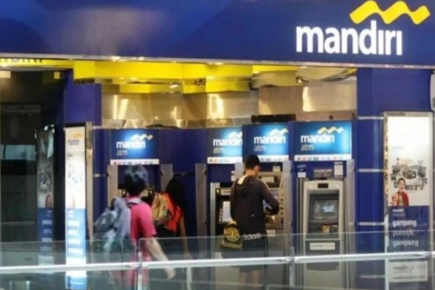 Nasabah Bank Mandiri menggunakan transaksi dari ATM yang tersedia.